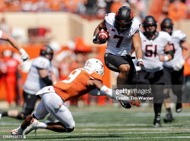 Jaylen Warren of the Oklahoma State Cowboys hurdles Josh Thompson of the Texas Longhorns in the fourth quarter at Darrell K Royal-Texas Memorial...