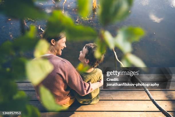 madre e hijo relajándose en un lago - nordic fotografías e imágenes de stock