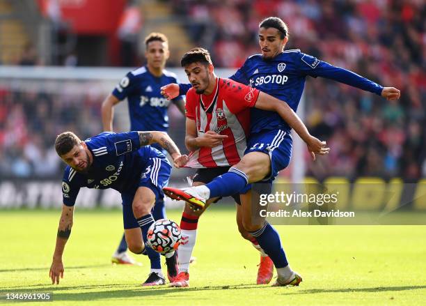 Armando Broja of Southampton is put under pressure by Mateusz Klich and Pascal Struijk of Leeds United during the Premier League match between...