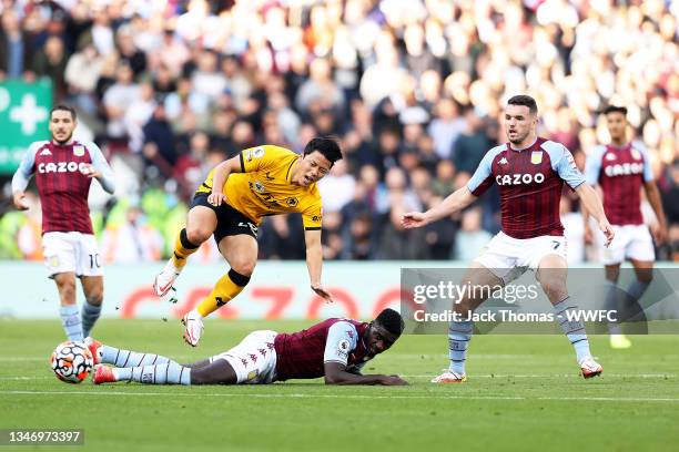 Hee-chan Hwang of Wolverhampton Wanderers is challenged by Axel Tuanzebe of Aston Villa during the Premier League match between Aston Villa and...