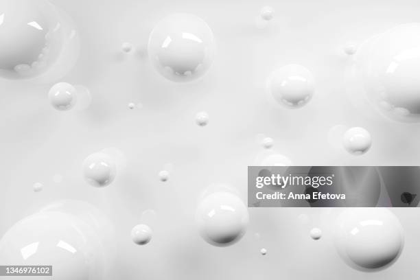 white glossy spheres on bright glance background. new year ornaments and snow fall concept. festive abstract background. - white sphere stock pictures, royalty-free photos & images