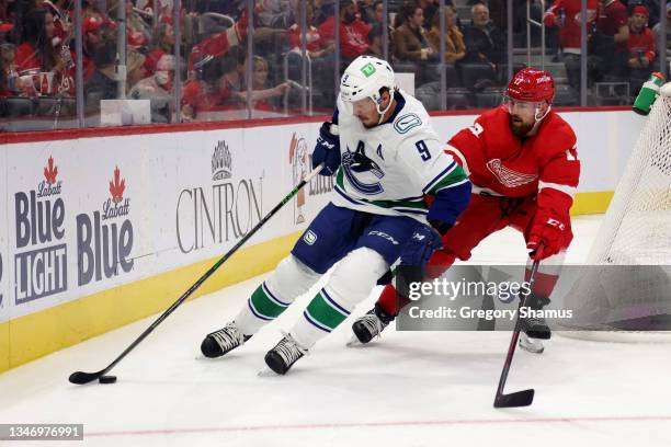 Miller of the Vancouver Canucks battles for the puck against Filip Hronek of the Detroit Red Wings during the first period at Little Caesars Arena on...