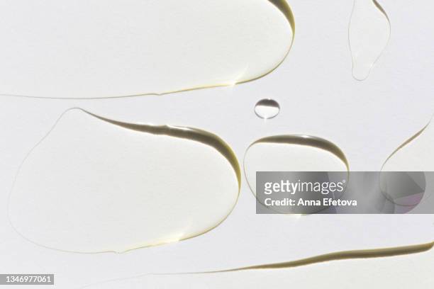 background made with many smears of essential oil. concept of body care and beauty. macrophotography in flat lay style - oil drop stock pictures, royalty-free photos & images