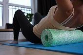 Woman doing foam roller exercises to relieve back pain closeup