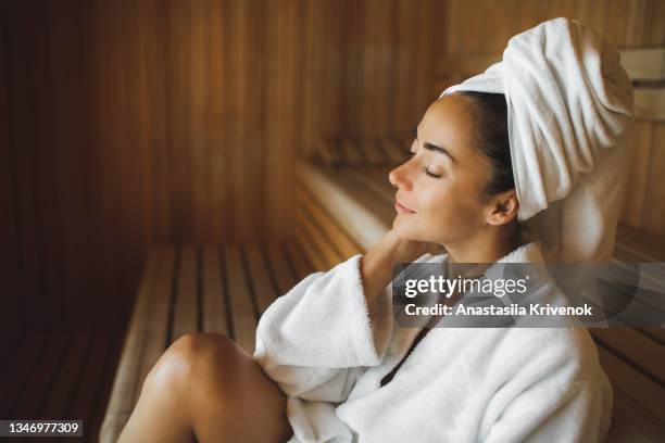 portrait of young attractive woman smiling and relaxing in sauna at spa. - spa bildbanksfoton och bilder