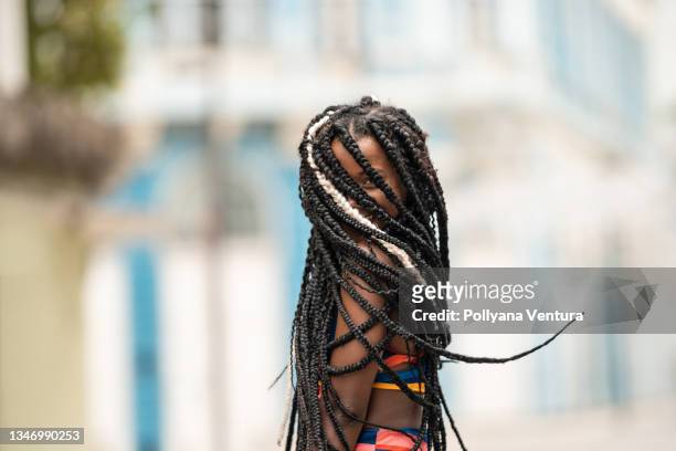 afro woman hiding face with braids - plat stock pictures, royalty-free photos & images