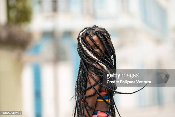 afro woman hiding face with braids - flätor bildbanksfoton och bilder