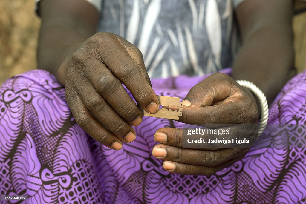 A woman holds the razor blade in eastern Burkina Faso.
