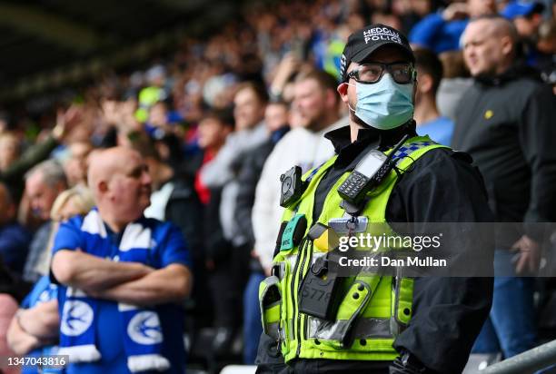 Police officer is seen wearing a facemask amongst the fans prior to the Sky Bet Championship match between Swansea City and Cardiff City at...