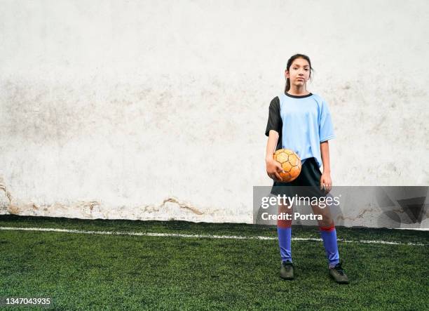 confident girl soccer player with ball at indoor field - football player standing stock pictures, royalty-free photos & images