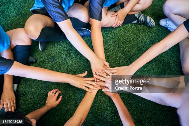 girls players stacking hands together at sports court - soccer huddle stock pictures, royalty-free photos & images