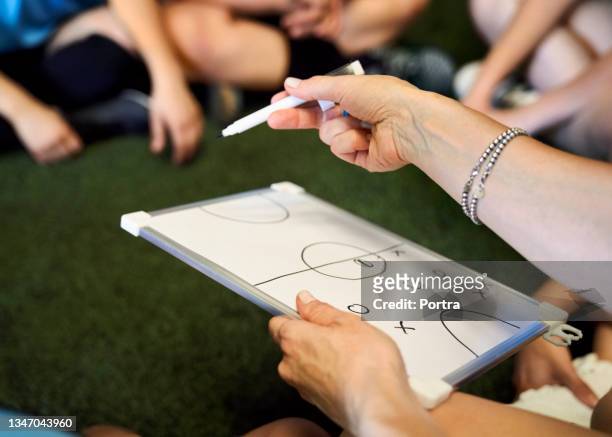 treinador com quadro branco discutindo plano de jogo com time de futebol - instrutor - fotografias e filmes do acervo