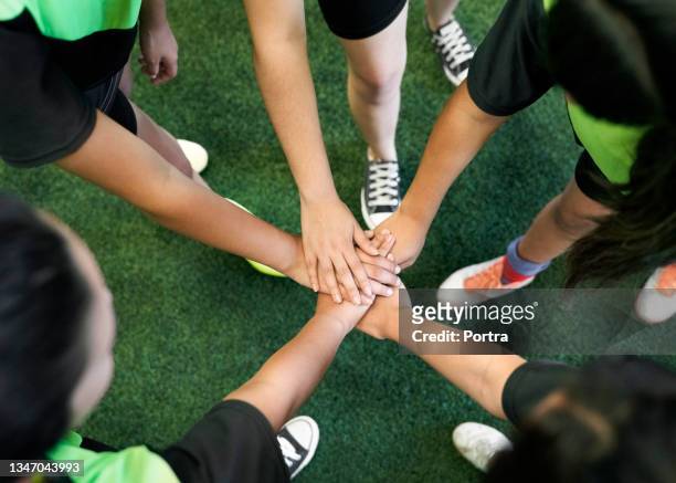 los jugadores de fútbol están apilando las manos en el campo de entrenamiento - fútbol sala fotografías e imágenes de stock