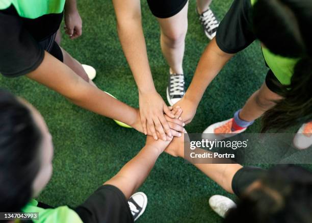 soccer players are stacking hands in training ground - indoor soccer stock pictures, royalty-free photos & images