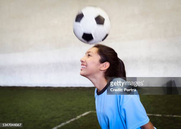 girl soccer player heading ball - heading the ball stockfoto's en -beelden