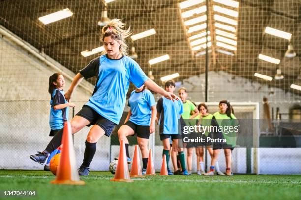 fußballmädchen bei dribbelübungen auf indoor-court - sports drill stock-fotos und bilder