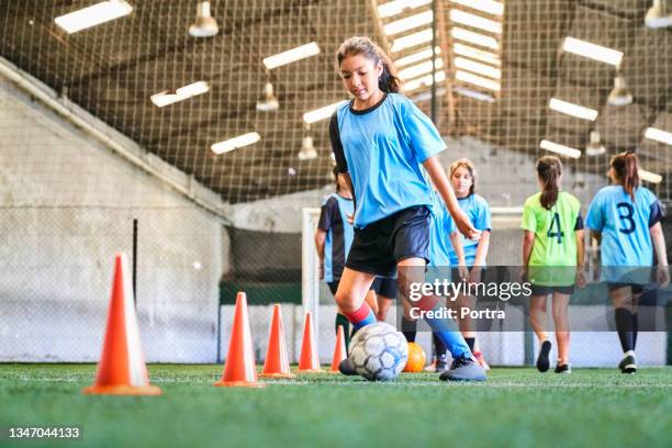 jugadora de fútbol femenina segura de sí misma practicando habilidades en la cancha - términos deportivos fotografías e imágenes de stock