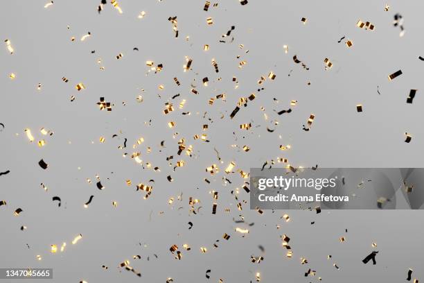 golden festive confetti falling over gray background. golden festive confetti falling over pink background. concept of celebrating new year's coming or birthday. - confetti gold ストックフォトと画像