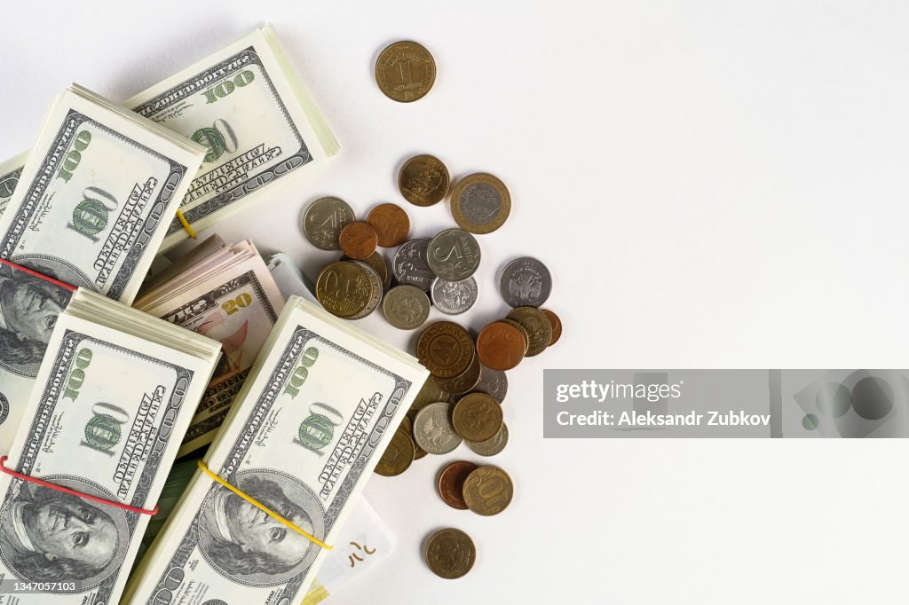 US dollars and euros, EU and US banknotes in bundles On a white background. Coins from different countries. The concept of finance and economics. Salary, bribe, profit or credit funds. Copy space.