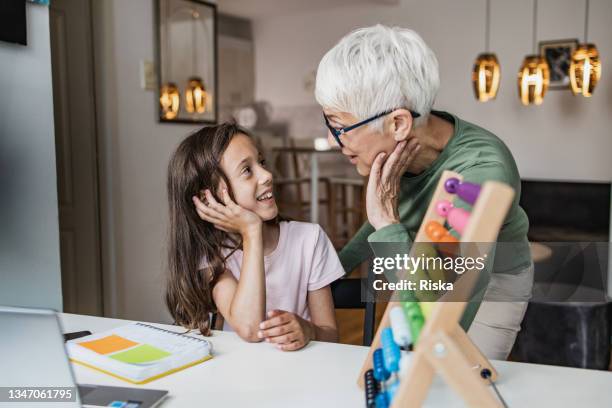 senior woman helping her granddaughter with math problems - abacus old stock pictures, royalty-free photos & images