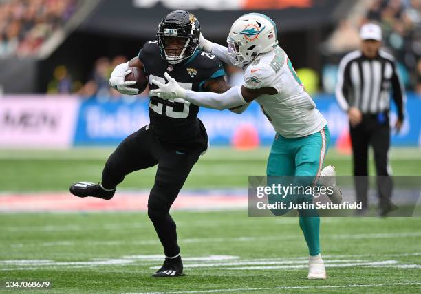 James Robinson of the Jacksonville Jaguars is tackled by Noah Igbinoghene of the Miami Dolphins during the NFL London 2021 match between Miami...