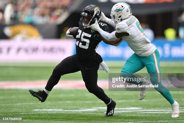 James Robinson of the Jacksonville Jaguars is tackled by Noah Igbinoghene of the Miami Dolphins during the NFL London 2021 match between Miami...