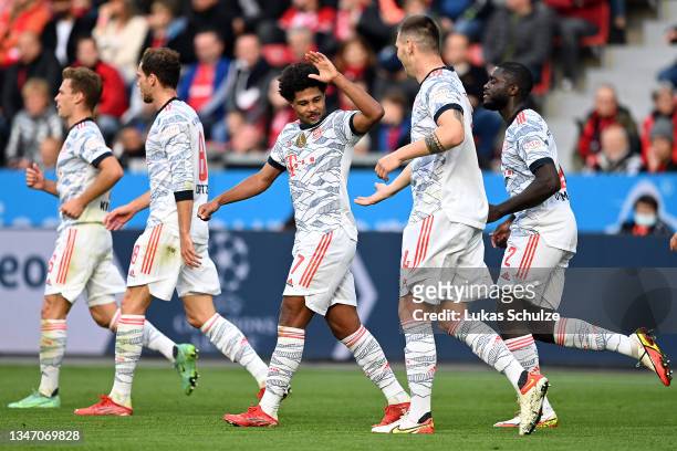 Serge Gnabry of FC Bayern Muenchen celebrates with Niklas Suele and team mates after scoring their side's fourth goal during the Bundesliga match...
