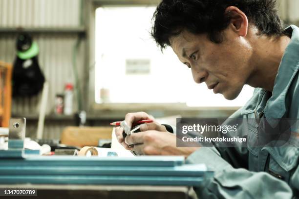 factory workers look at the blueprints in concentration - mill worker stock pictures, royalty-free photos & images