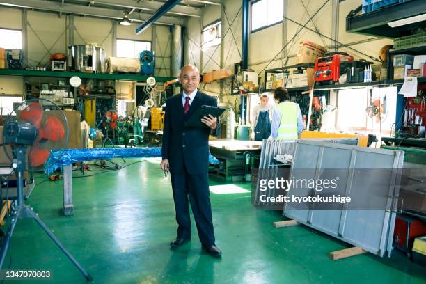 portrait of a factory manager wearing a suit - president and ceo of smiles co masamichi toyama interview stockfoto's en -beelden