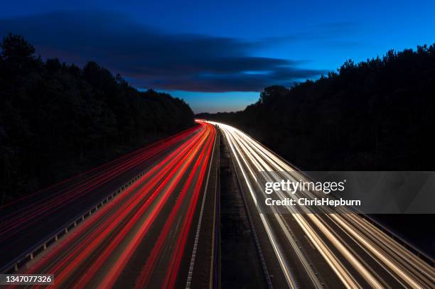 langzeitbelichtung weitwinkelansicht der autobahn bei dämmerung lichtspuren - rücklicht stock-fotos und bilder