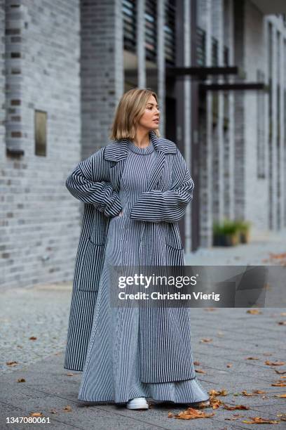 Amelie Stanescu is seen wearing grey dress and coat by Joseph, white shoes by Prada on October 15, 2021 in Berlin, Germany.