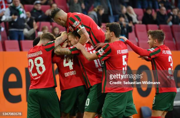 Reece Oxford of FC Augsburg celebrates with teammates after scoring their team's first goal during the Bundesliga match between FC Augsburg and DSC...