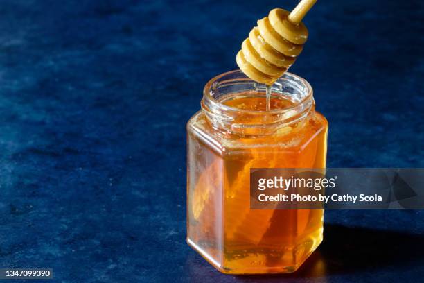 Premium Photo  Honey with various types of nuts in glass jars on a blue  background.