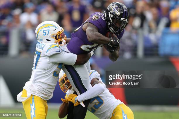 Amen Ogbongbemiga and Chris Harris Jr. #25 of the Los Angeles Chargers tackle Latavius Murray of the Baltimore Ravens during the first quarter at M&T...