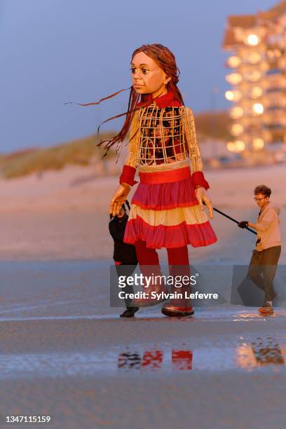 On Bray-Dunes beach, "Little Amal", a 3.5 meter giant puppet depicting a Syrian refugee girl, walks to the shore and stares ahead of her towards the...