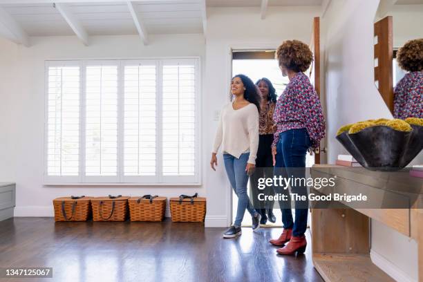 smiling female customers entering through front door with real estate agent - real estate agent imagens e fotografias de stock