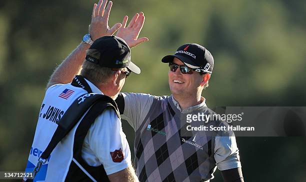Zach Johnson celebrates with his caddie Damon Green after holing out for eagle on the 18th hole during the third round of the Chevron World Challenge...