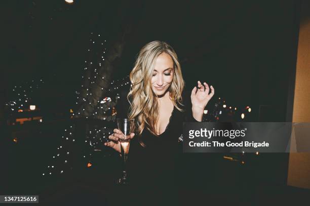 smiling young blond woman dancing at party - soirée chic stock pictures, royalty-free photos & images