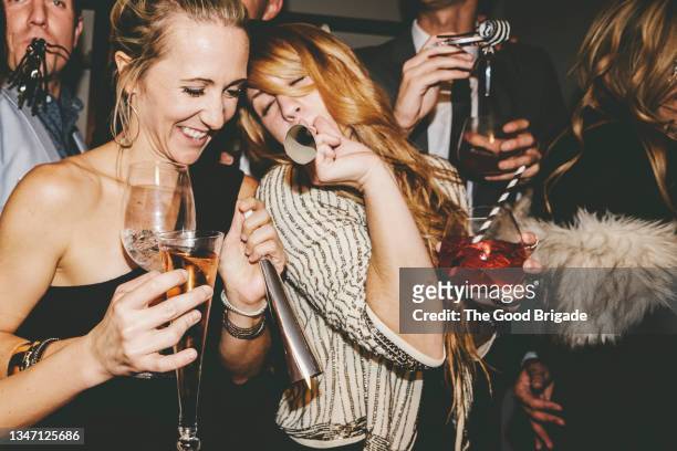male and female friends enjoying new year's eve party - matasuegras fotografías e imágenes de stock