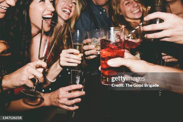 cheerful male and female friends raising toast while partying together - カクテルパーティ ストックフォトと画像