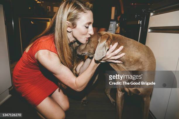 blond woman with eyes closed kissing pet dog during party at home - dog eyes closed stock pictures, royalty-free photos & images