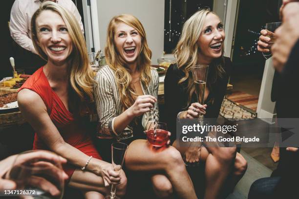 happy blond women sitting together with drinks while enjoying at party - cocktail dress bildbanksfoton och bilder