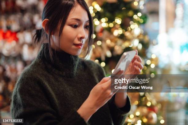 young woman doing online christmas shopping with smart phone - oscar party 個照片及圖片檔