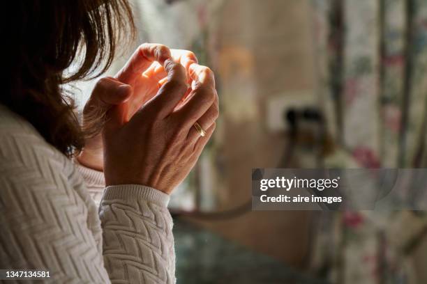 side view of worried woman with her hands clasped gold ring - senza speranza foto e immagini stock