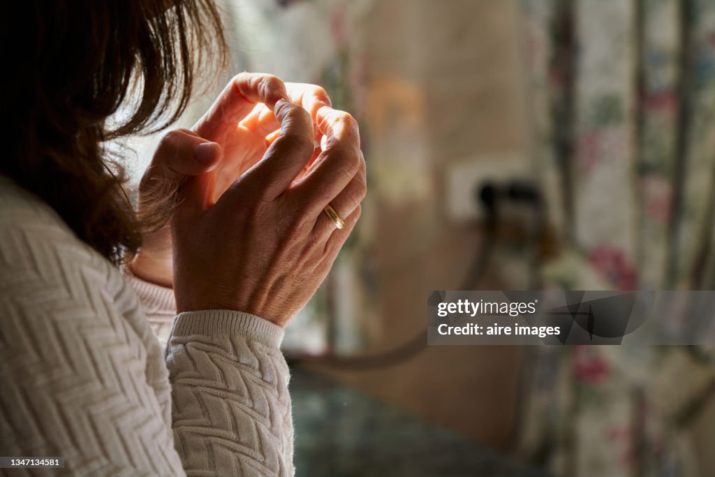 Side view of worried woman with her hands clasped gold ring