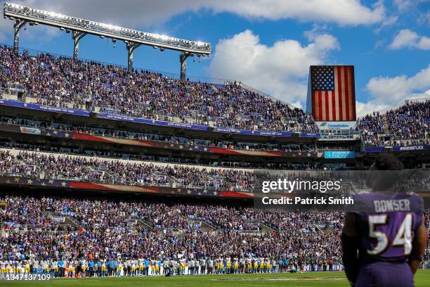 Spectators, the Los Angeles Chargers, and outside linebacker Tyus Bowser of the Baltimore Ravens stand for the U.S. National Anthem before an NFL...