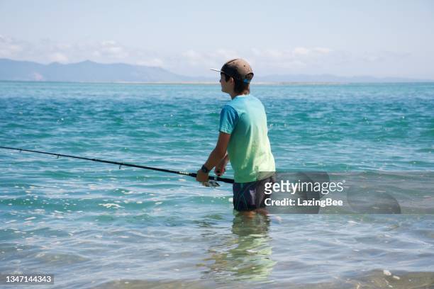 boy coastal surf fishing in summer at beach estuary - surf casting stock pictures, royalty-free photos & images