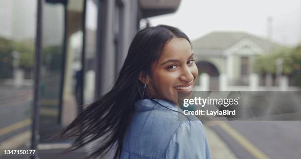 shot of a young woman looking over her shoulder - looking over shoulder stockfoto's en -beelden