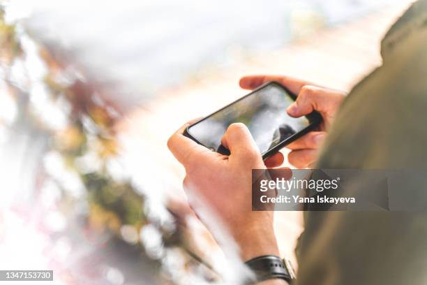 man using mobile phone in horizontal mode - ゲーム ストックフォトと画像