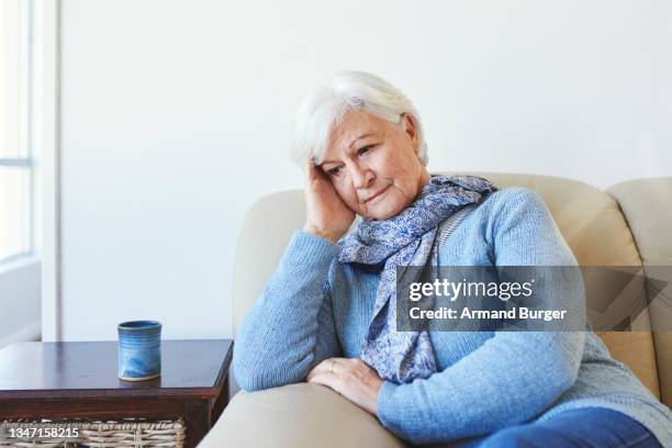 shot of a senior woman looking unhappy at home - older widow stock pictures, royalty-free photos & images